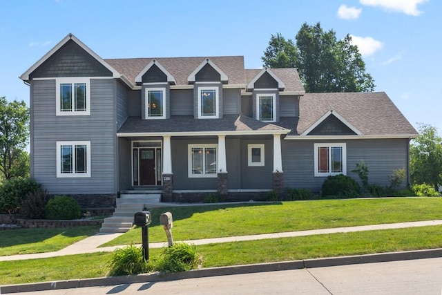 craftsman-style house featuring a front yard and a shingled roof