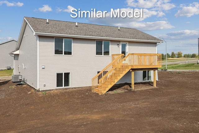 rear view of property with stairway, cooling unit, roof with shingles, and a deck