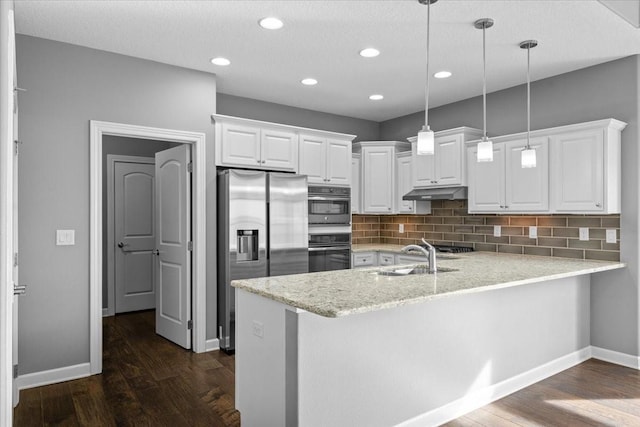 kitchen with under cabinet range hood, a peninsula, stainless steel refrigerator with ice dispenser, white cabinetry, and a sink