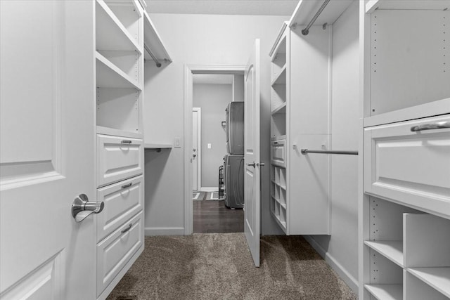 walk in closet with dark carpet