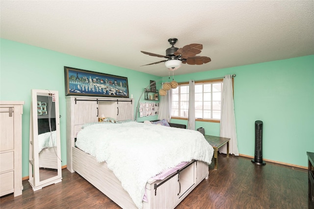 bedroom with ceiling fan, dark wood-type flooring, baseboards, and a textured ceiling