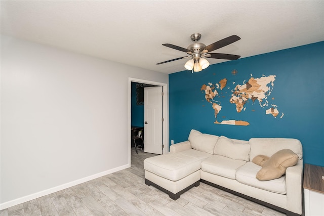 unfurnished living room featuring a ceiling fan, baseboards, and wood finished floors