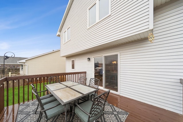 deck featuring outdoor dining area and a yard