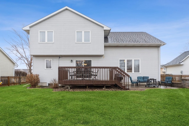 back of house with a lawn, a deck, a fenced backyard, roof with shingles, and a patio area