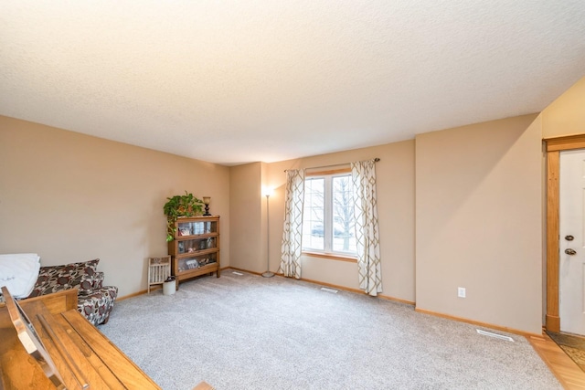 unfurnished room featuring visible vents, baseboards, a textured ceiling, and carpet floors