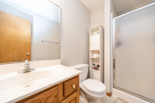 bathroom with toilet, a stall shower, and vanity