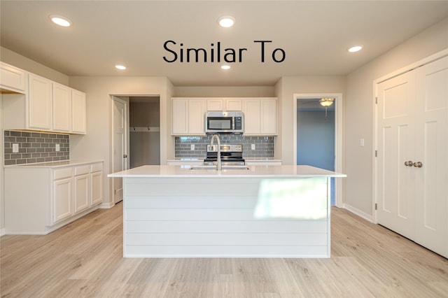 kitchen with light countertops, light wood-type flooring, and appliances with stainless steel finishes