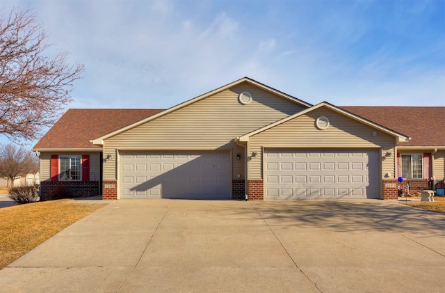 single story home featuring an attached garage, brick siding, and driveway