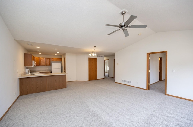 unfurnished living room with visible vents, baseboards, ceiling fan with notable chandelier, and vaulted ceiling