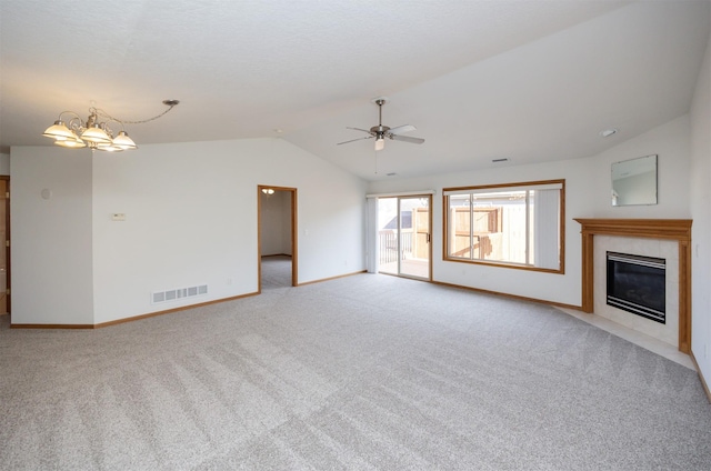 unfurnished living room featuring visible vents, baseboards, a tiled fireplace, lofted ceiling, and light carpet