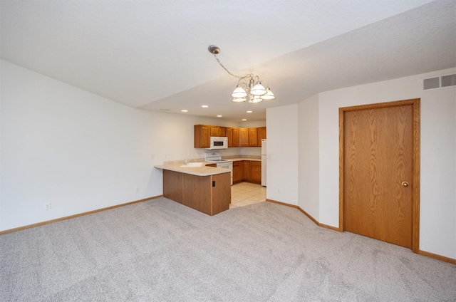 kitchen featuring baseboards, light countertops, light carpet, a peninsula, and white appliances