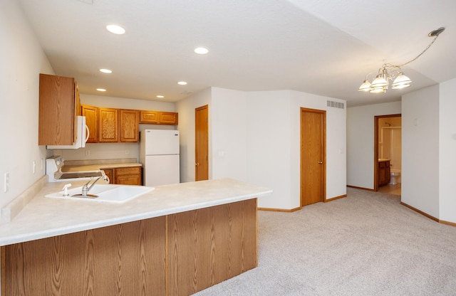 kitchen with light colored carpet, light countertops, a peninsula, white appliances, and a sink