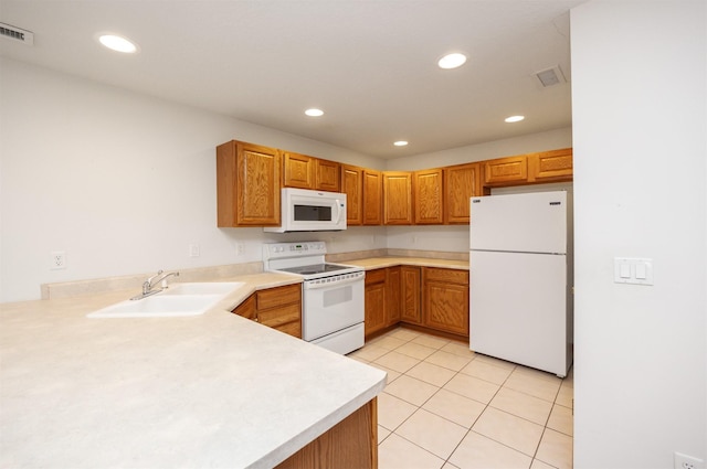 kitchen featuring visible vents, recessed lighting, white appliances, and a sink