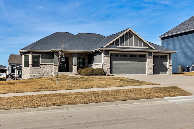 view of front of house featuring a garage, stone siding, central AC, and concrete driveway