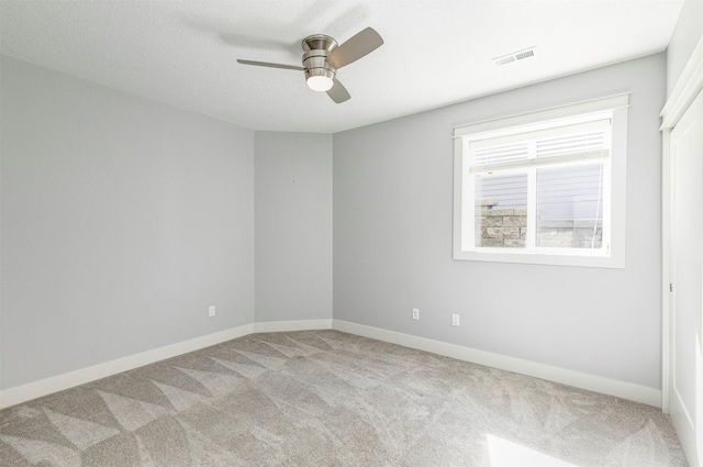 empty room featuring visible vents, ceiling fan, baseboards, and carpet