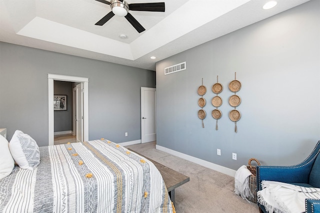 bedroom with visible vents, a raised ceiling, recessed lighting, baseboards, and light colored carpet