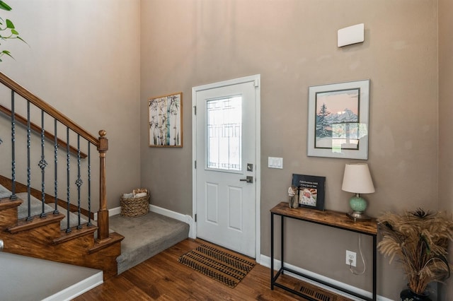 entrance foyer with stairway, baseboards, and wood finished floors