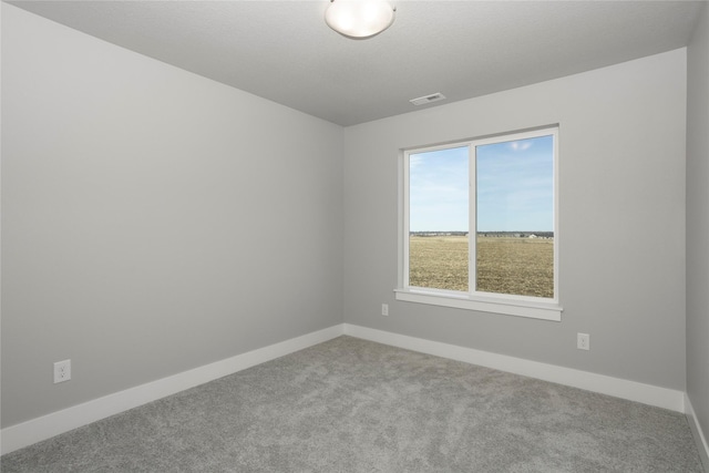 unfurnished room with visible vents, baseboards, and carpet