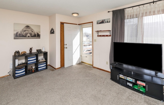 living area featuring a healthy amount of sunlight, baseboards, and carpet