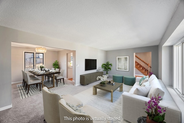 carpeted living area with baseboards, a textured ceiling, and stairs