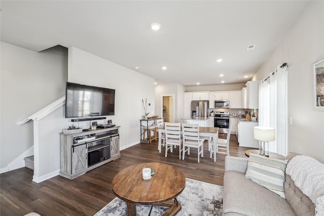 living area with stairway, visible vents, baseboards, dark wood finished floors, and recessed lighting