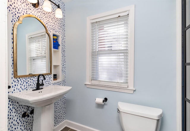 bathroom featuring decorative backsplash, baseboards, a healthy amount of sunlight, and toilet