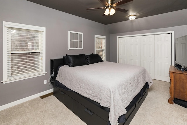 bedroom with vaulted ceiling, a closet, ceiling fan, carpet floors, and baseboards