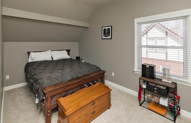carpeted bedroom with vaulted ceiling and baseboards