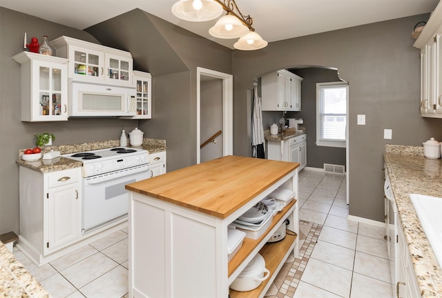 kitchen featuring open shelves, wooden counters, white appliances, arched walkways, and visible vents