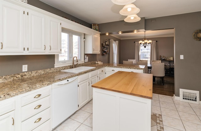 kitchen with a sink, visible vents, an inviting chandelier, white dishwasher, and wood counters