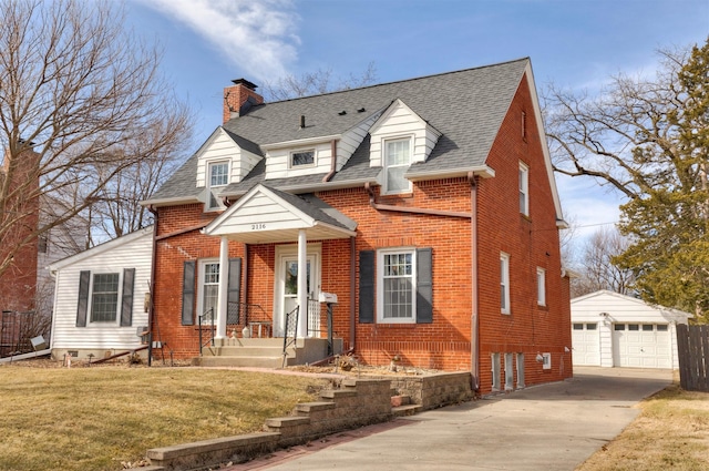 view of front of house featuring an outbuilding, a front yard, a chimney, a garage, and brick siding