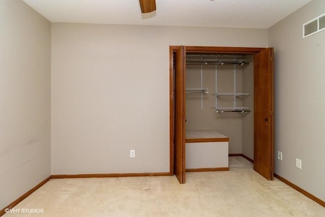 unfurnished bedroom featuring visible vents, ceiling fan, baseboards, light carpet, and a closet