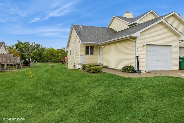 view of front of property with a garage, a chimney, roof with shingles, and a front lawn