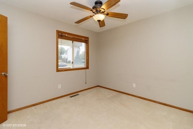 empty room featuring light carpet, visible vents, ceiling fan, and baseboards