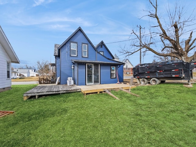 rear view of house featuring a yard and a wooden deck