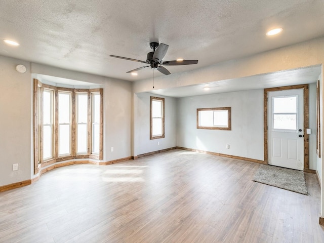 interior space with baseboards, plenty of natural light, and wood finished floors