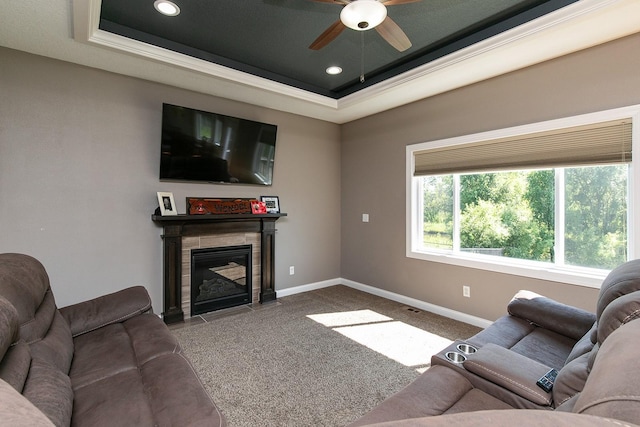 living area with a tray ceiling, baseboards, carpet, and a tile fireplace