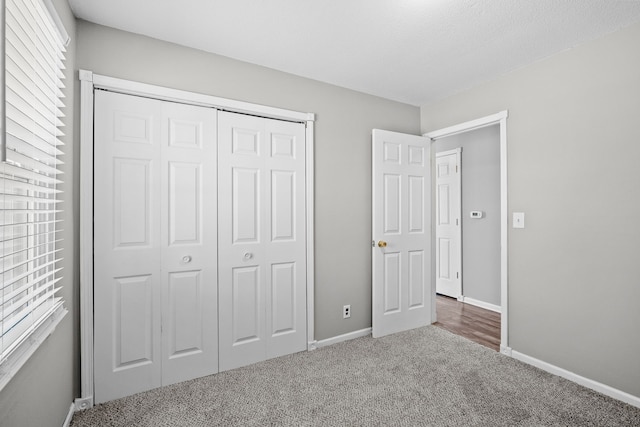 unfurnished bedroom featuring a closet, baseboards, and carpet floors