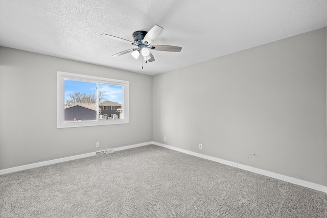 empty room with a ceiling fan, baseboards, visible vents, carpet floors, and a textured ceiling