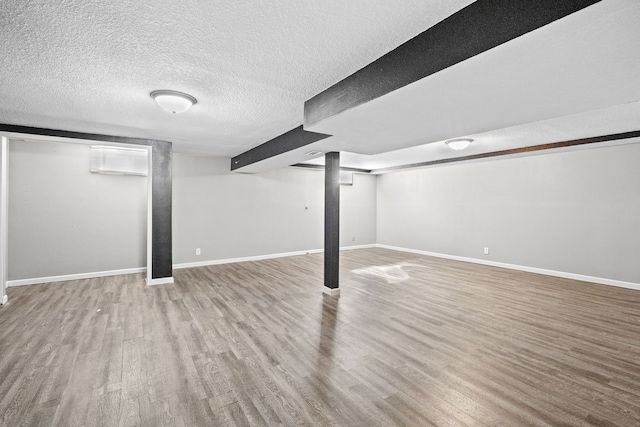 finished basement featuring wood finished floors and baseboards