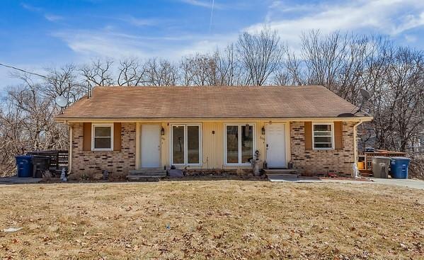 view of front of house featuring brick siding, a front lawn, and entry steps