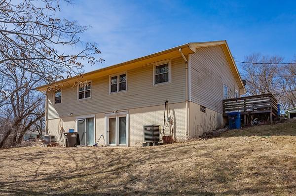 rear view of house featuring brick siding and central AC