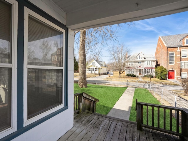 wooden terrace with a residential view and a lawn