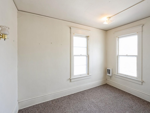 spare room featuring plenty of natural light, baseboards, and carpet