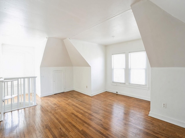 bonus room featuring vaulted ceiling, baseboards, and wood-type flooring