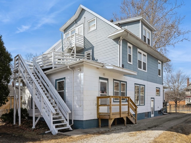 rear view of property featuring stairs