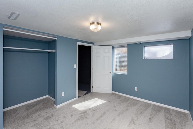 unfurnished bedroom featuring baseboards, carpet floors, and a textured ceiling