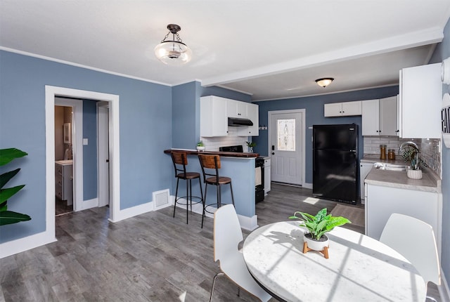 dining area featuring visible vents, baseboards, dark wood finished floors, and ornamental molding