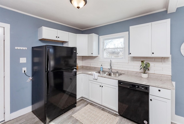 kitchen featuring decorative backsplash, black appliances, white cabinetry, and a sink