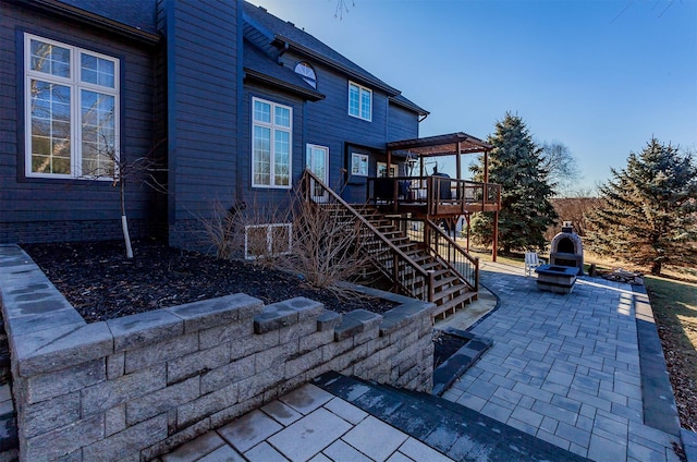 rear view of house with a deck, stairway, and a patio